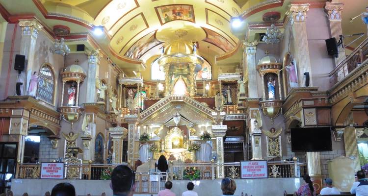 Inneres einer reich geschmückten Kirche mit Gottesdienstbesuchern.