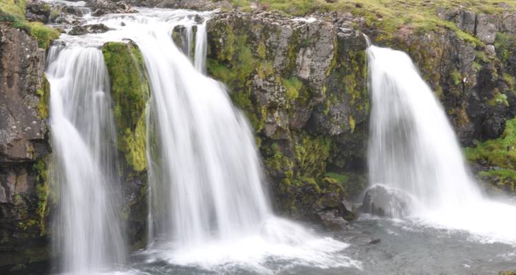 Waterfalls cascading over moss-covered cliffs.