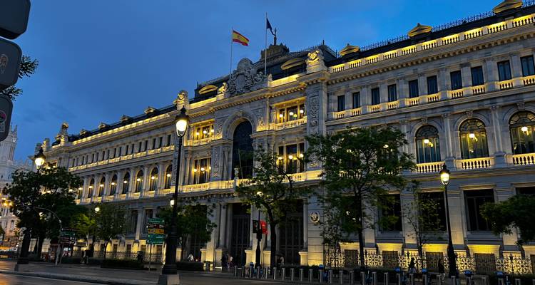 An illuminated historic building in an urban setting at night.
