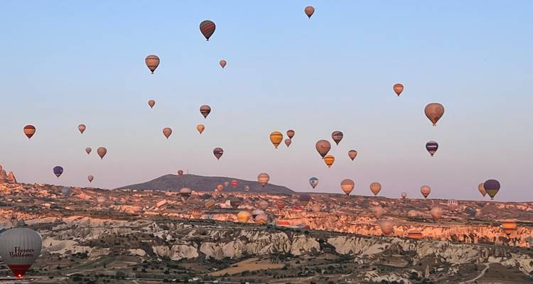 Hot air balloons over a rocky landscape.