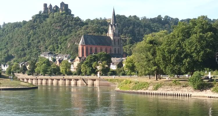 Un paysage pittoresque avec une église et un château sur une colline au bord de la rivière.