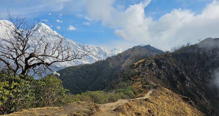 Crête de montagne avec sentier de randonnée et sommets enneigés.