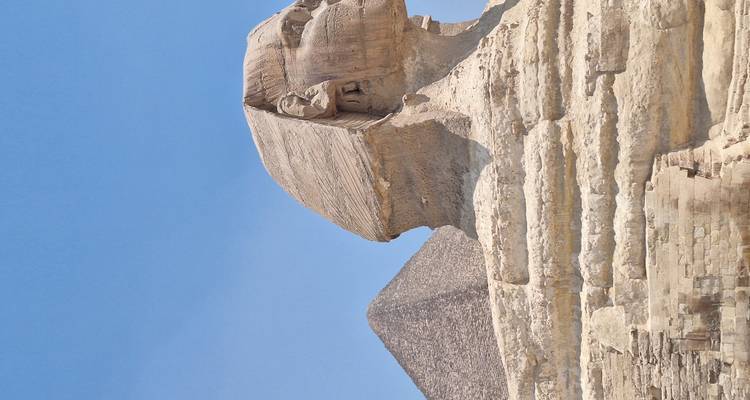 The Great Sphinx of Giza with a pyramid in the background.