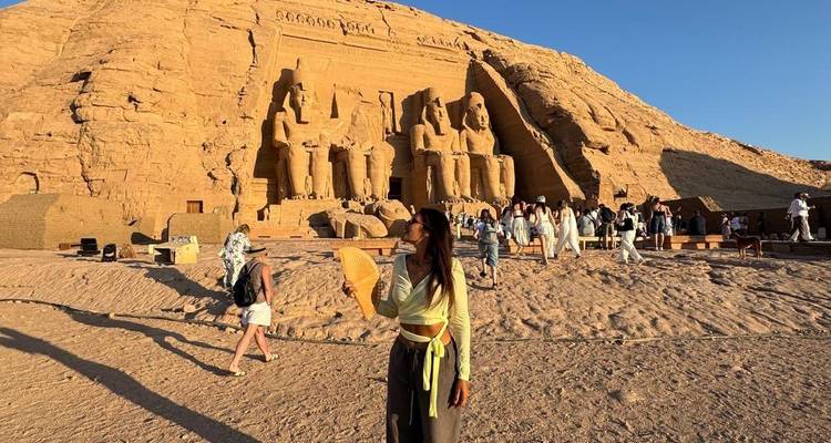 Une femme tenant un éventail devant Abou Simbel.