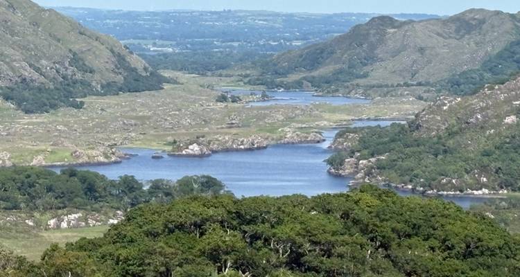 A scenic view of a lake surrounded by hills.