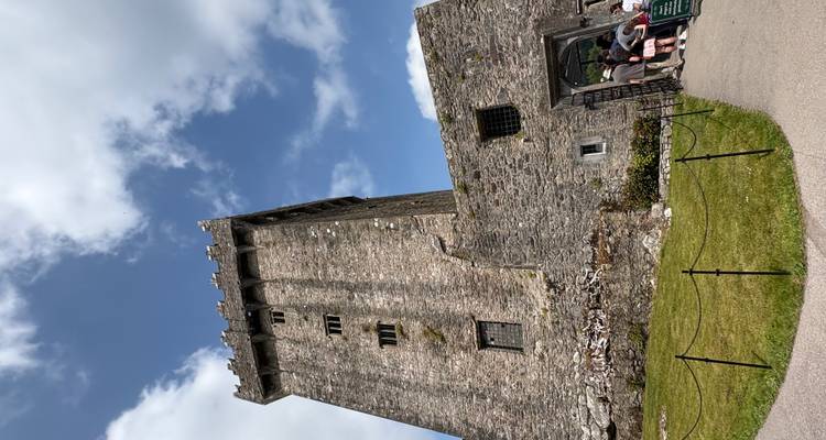 A large stone tower with clouds and blue sky.