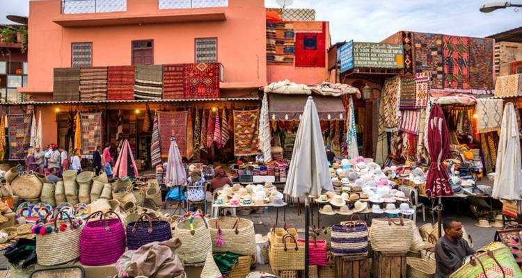 Un marché animé rempli de textiles colorés et de produits tissés.