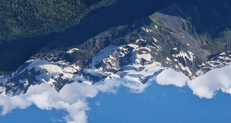 Snow-capped peaks of mountains under a clear blue sky.