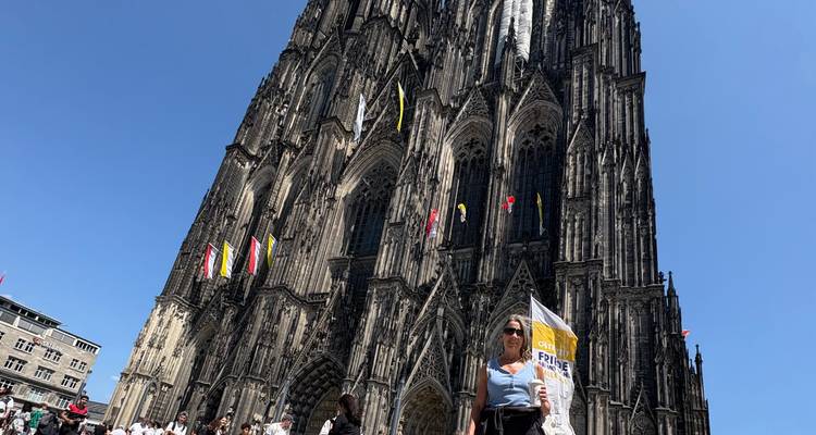 Grande cathédrale gothique avec des touristes devant.