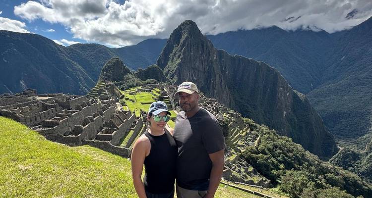 Couple debout devant les ruines du Machu Picchu.