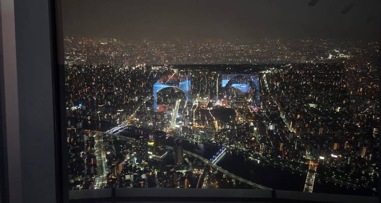 Vue nocturne d'un horizon urbain avec des bâtiments illuminés.