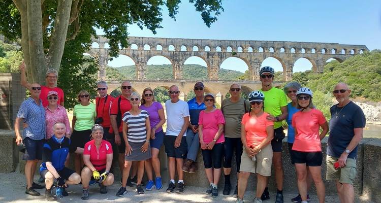 Group of cyclists posing at the Pont du Gard.