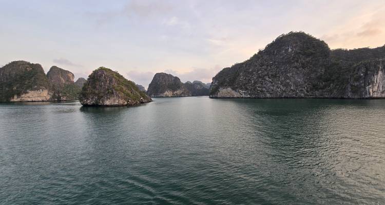 Scenic view of limestone karst formations rising from a tranquil bay.