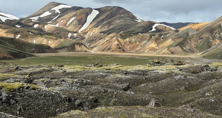 Montagnes colorées avec des plaques de neige et de mousse verte.