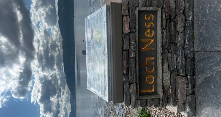 Panneau du Loch Ness avec de l'eau et des collines en arrière-plan.