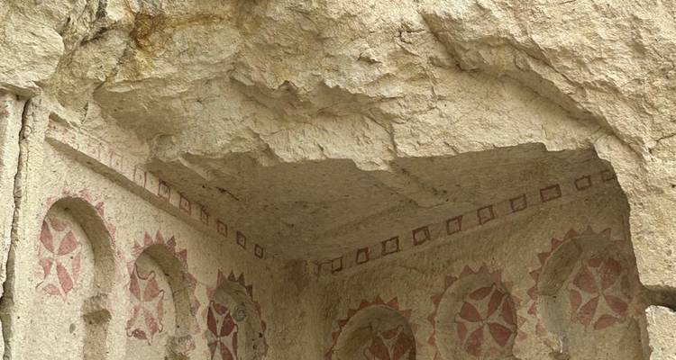 Rock sculptures with geometric patterns inside a cave.