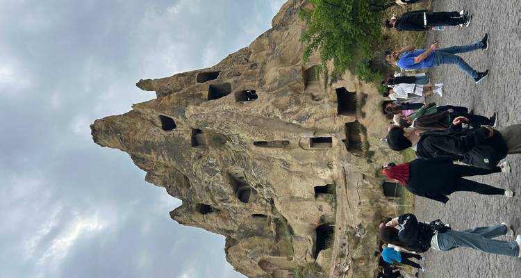 People exploring a large rock formation in Cappadocia.