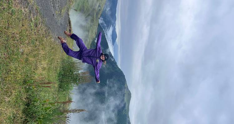 Personne en saut en plein air avec des montagnes brumeuses en arrière-plan.