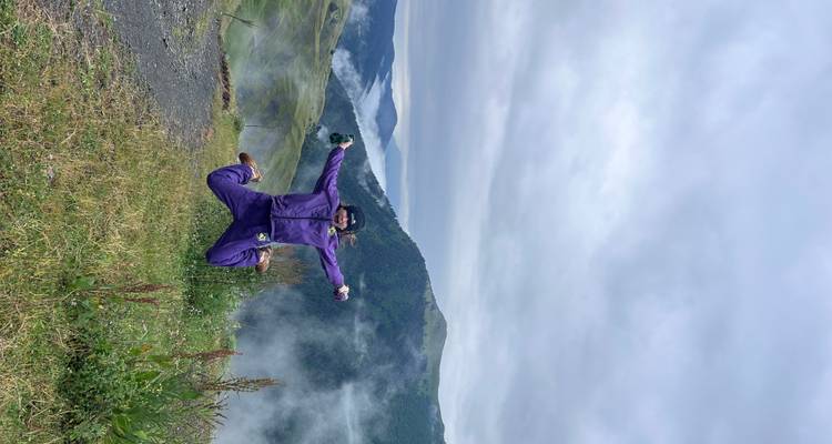 Personne sautant avec une vue panoramique sur les montagnes en arrière-plan.