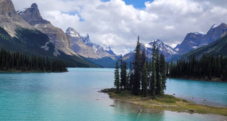 Magnifique lac turquoise entouré de montagnes enneigées.