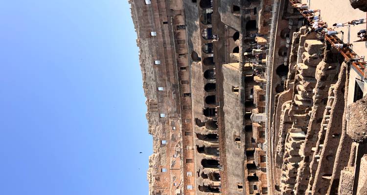 Interior view of the Colosseum with tourists walking around.