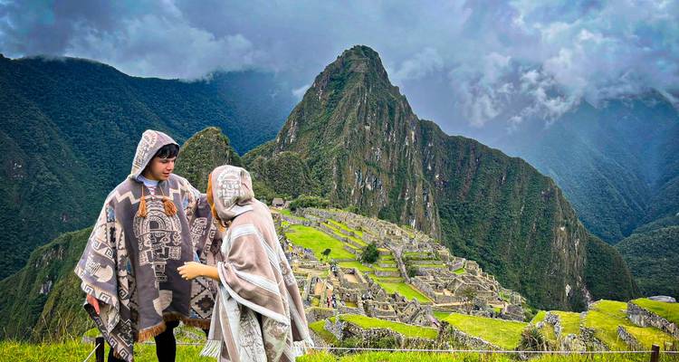 Des personnes en tenues traditionnelles avec le Machu Picchu en arrière-plan.