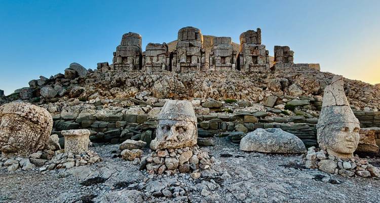 Statues de pierre de dieux avec une montagne derrière.