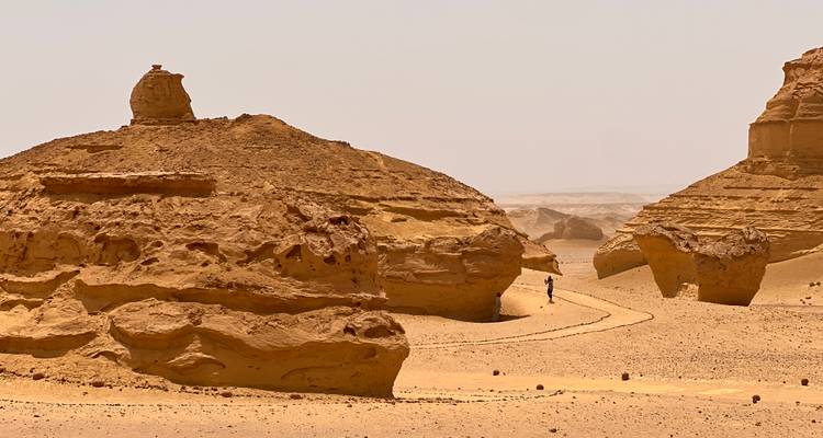 Rock formations with a person walking near by.