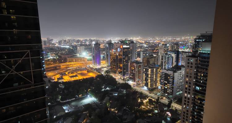 Vue nocturne d'une ville avec des bâtiments vivement éclairés.