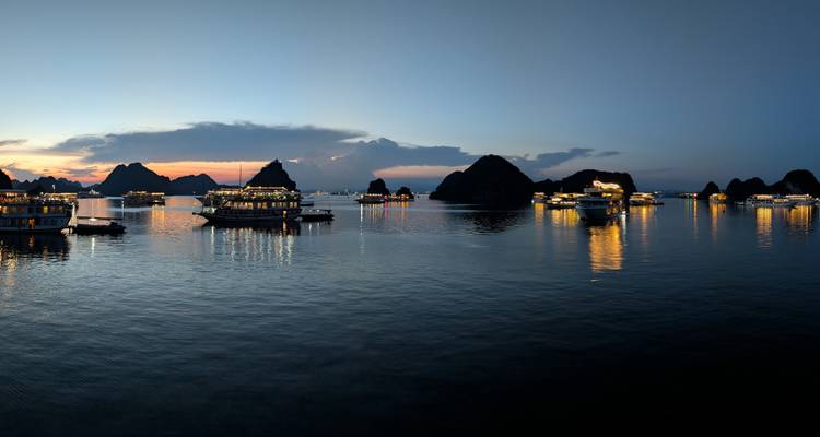 Evening view of boats in Halong Bay with scenic landscape.