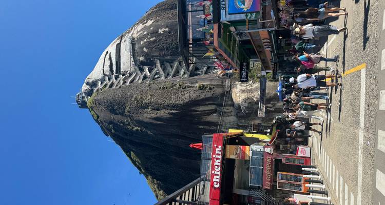 Le rocher El Peñol avec des escaliers et des touristes en bas.