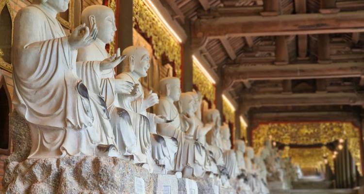 Row of statues inside a temple with intricate detailing.