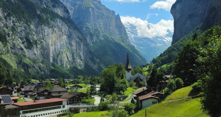 Magnifique village alpin avec une église et une vallée verdoyante.