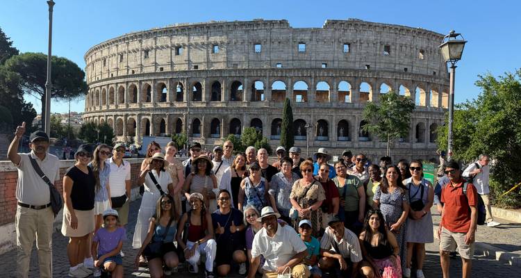 Grupo de turistas posando frente al Coliseo.