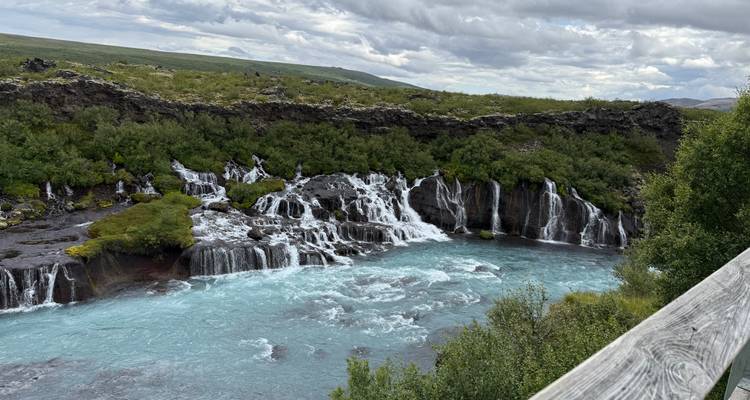 Serie de cascadas cayendo en cascada hacia un río azul.