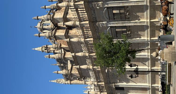 Un grand bâtiment historique avec des flèches se détachant sur un ciel bleu clair.