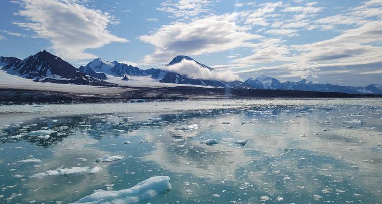 Picturesque view of icy waters with mountain range.