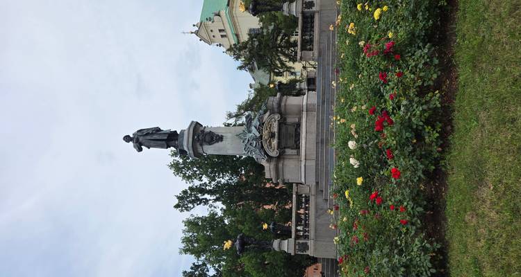Statue dans un parc avec des fleurs et des arbres