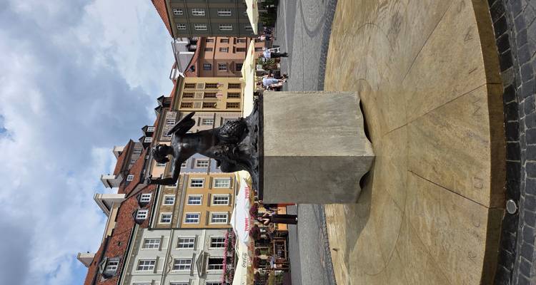 Standbeeld van een zeemeermin op een plein omringd door gebouwen