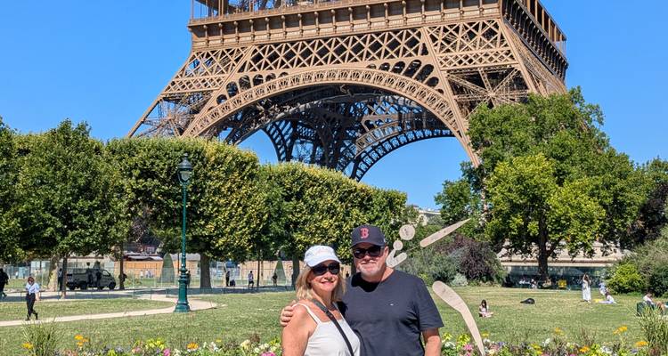 Couple in front of the Eiffel Tower during a sunny day