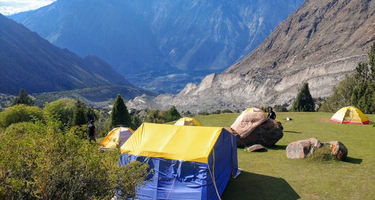 Campsite in a mountainous valley with yellow tents