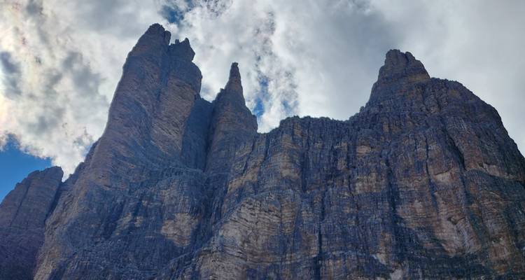 Mountainous landscape with towering rock formations under a cloudy sky.