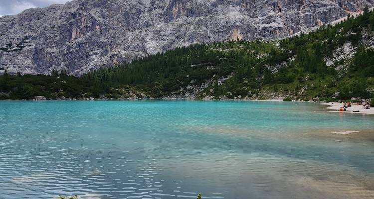 View of a serene turquoise lake with mountains in the background.