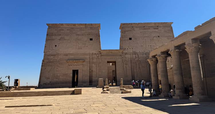 Visitantes explorando el Templo de Filae bajo un cielo despejado.