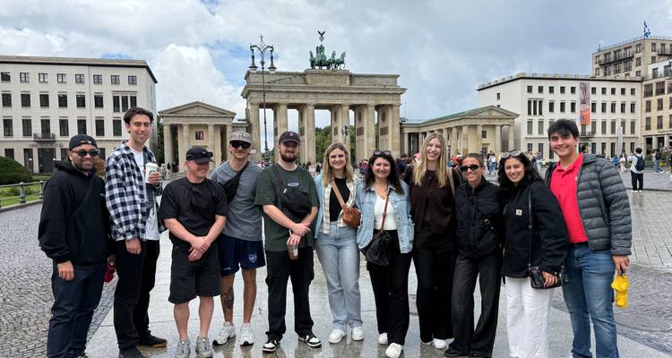 Groupe de personnes posant devant la porte de Brandebourg.