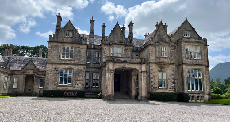 Historic stone mansion with green shutters.