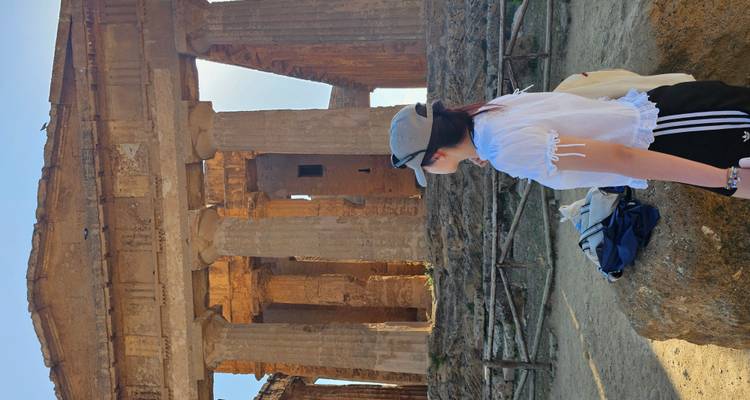 Femme devant les ruines d'un temple grec antique.