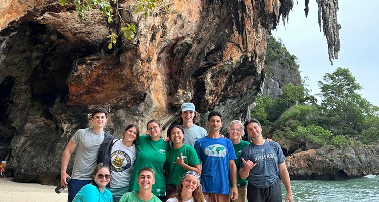 Groupe d'amis posant devant une falaise.