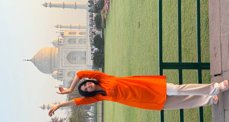 Personne qui pose devant le Taj Mahal au coucher du soleil.