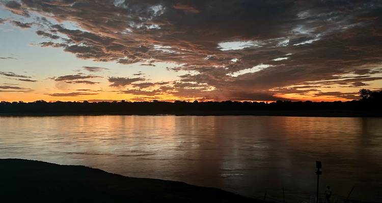 Coucher de soleil sur une rivière avec des nuages dramatiques.